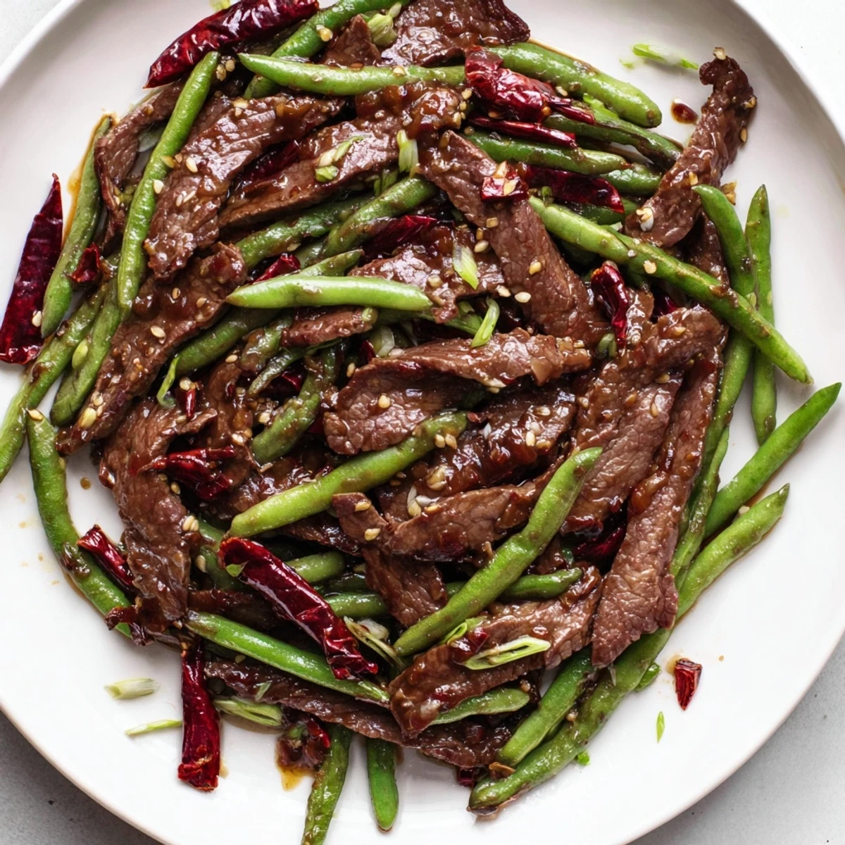 An overhead shot displays a hot wok tossing vibrant green beans and marinated beef with toasted Szechuan peppercorns and aromatics.
