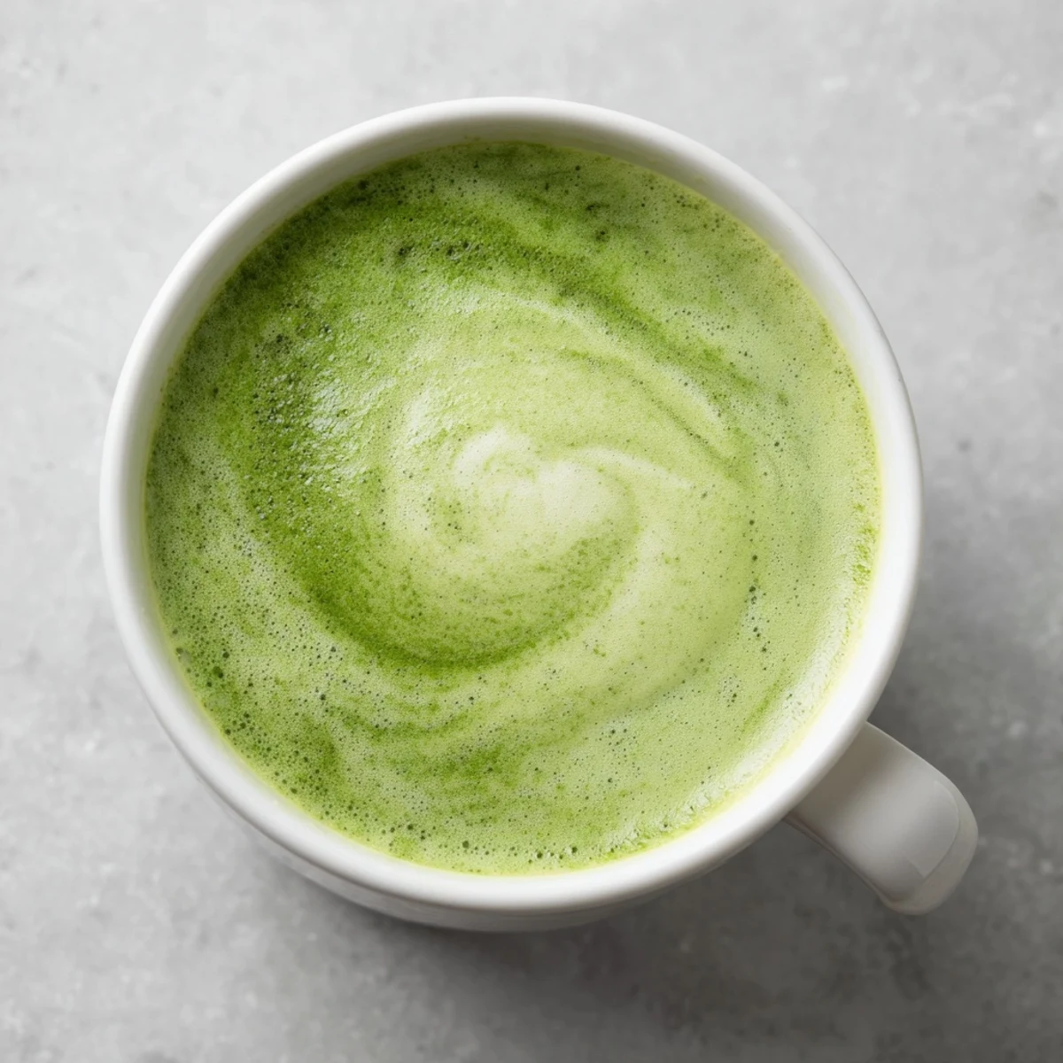 Served chilled in a tall glass, this green matcha latte with almond milk features a frothy green top.