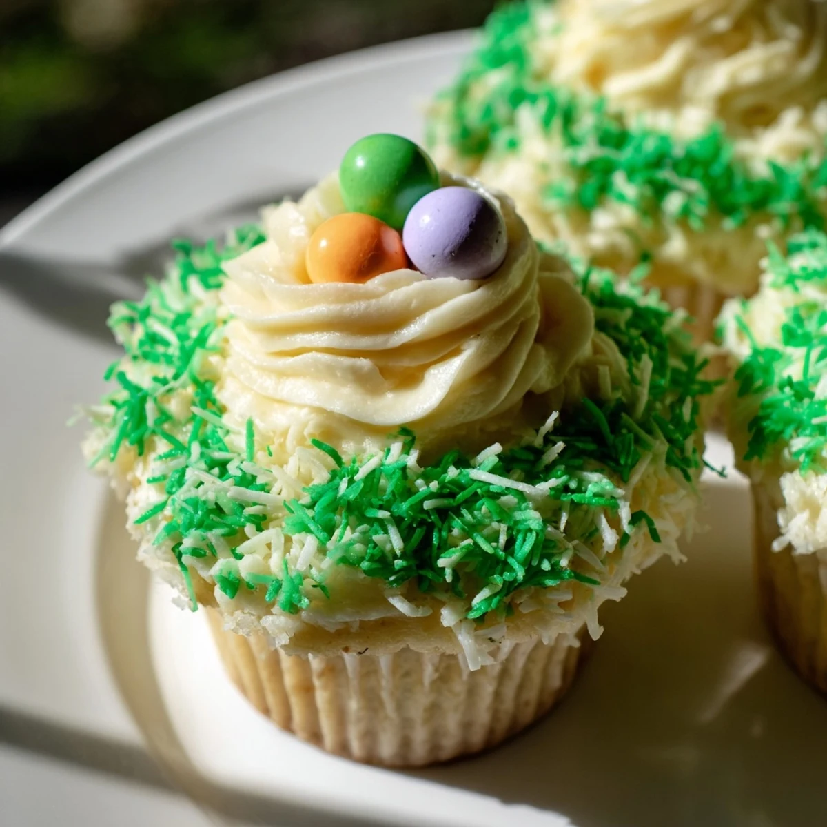 These adorable Easter Basket Cupcakes feature sweet frosting, toasted coconut grass, and festive candy egg decorations.