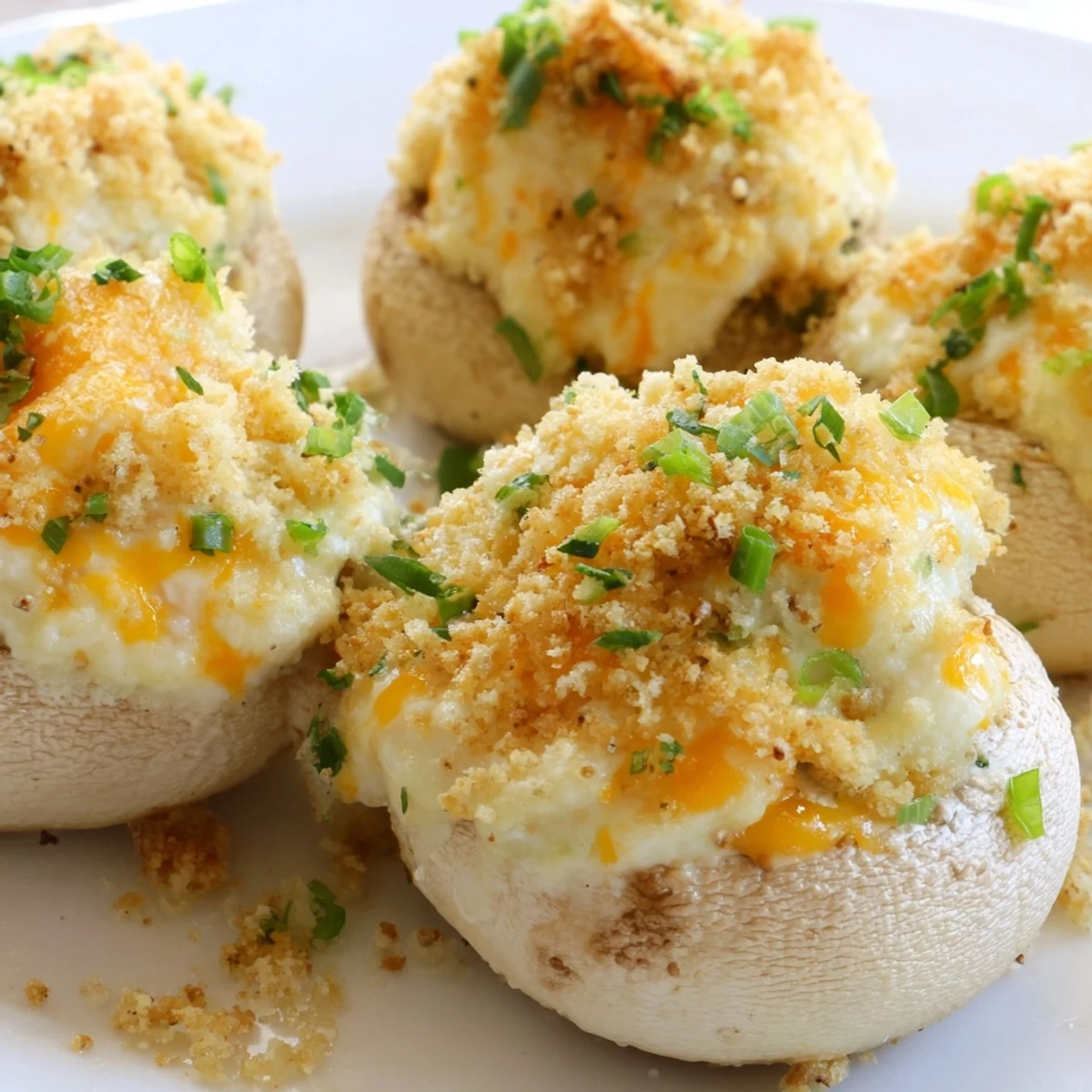 Close-up of Mozzarella Popper Stuffed Mushrooms with melted cheese and a crunchy breadcrumb topping.