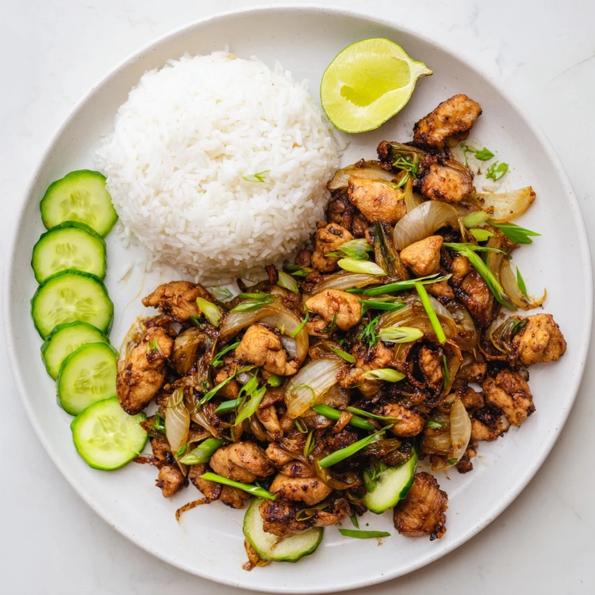 Golden-brown Vietnamese Lemongrass Chicken pieces sizzling in a wok with onions and fresh herbs.