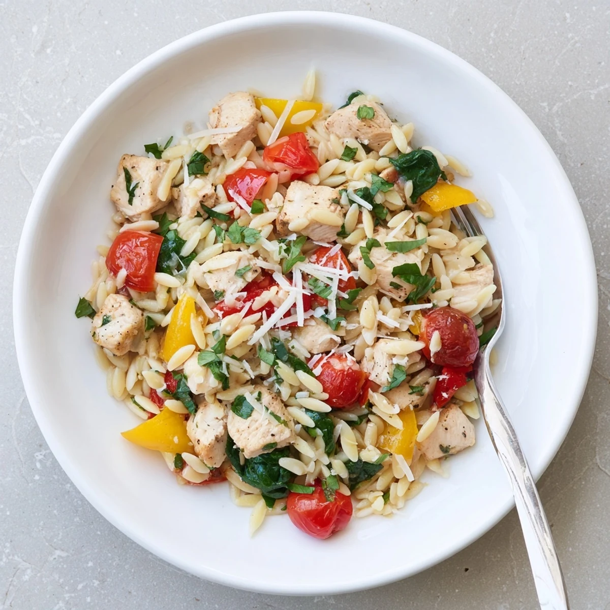 Tender chicken pieces and bright vegetables simmer with orzo in a light herbed sauce for this High Protein Chicken Orzo dish.