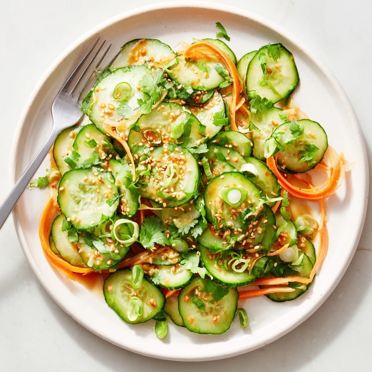 Thinly sliced cucumbers coated in zesty garlic ginger dressing topped with toasted sesame seeds