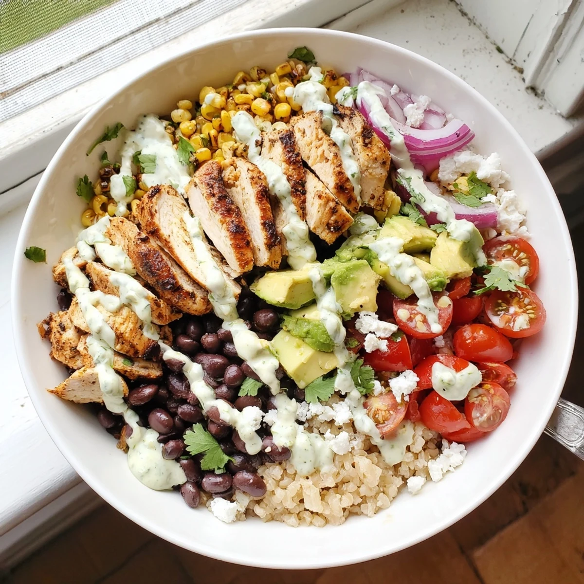 Hearty protein packed street corn chicken bowl featuring spiced chicken, sweet corn, black beans, and fresh avocado