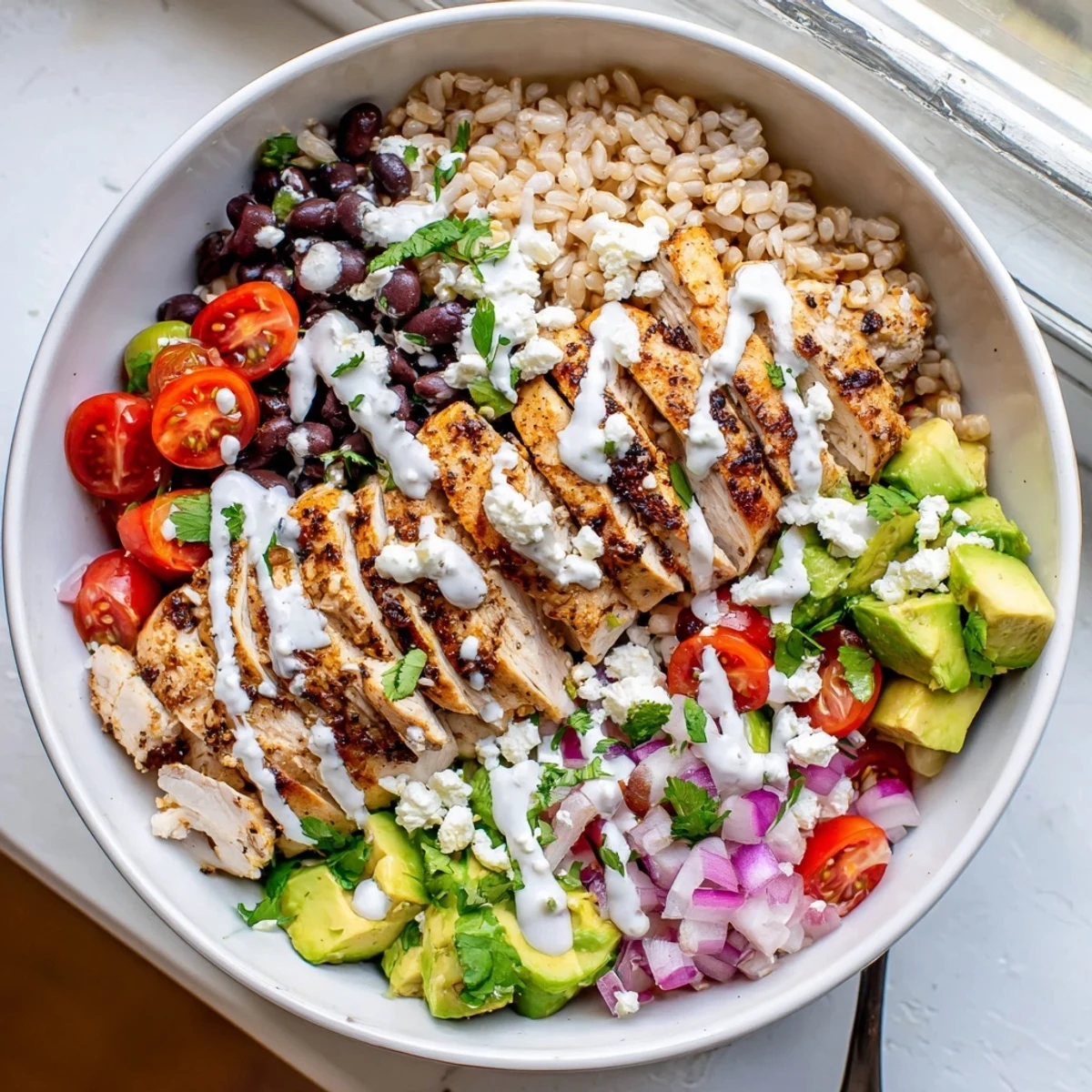 Protein packed street corn chicken bowl arranged with sliced chicken, zesty corn, tomatoes, and tangy lime drizzle