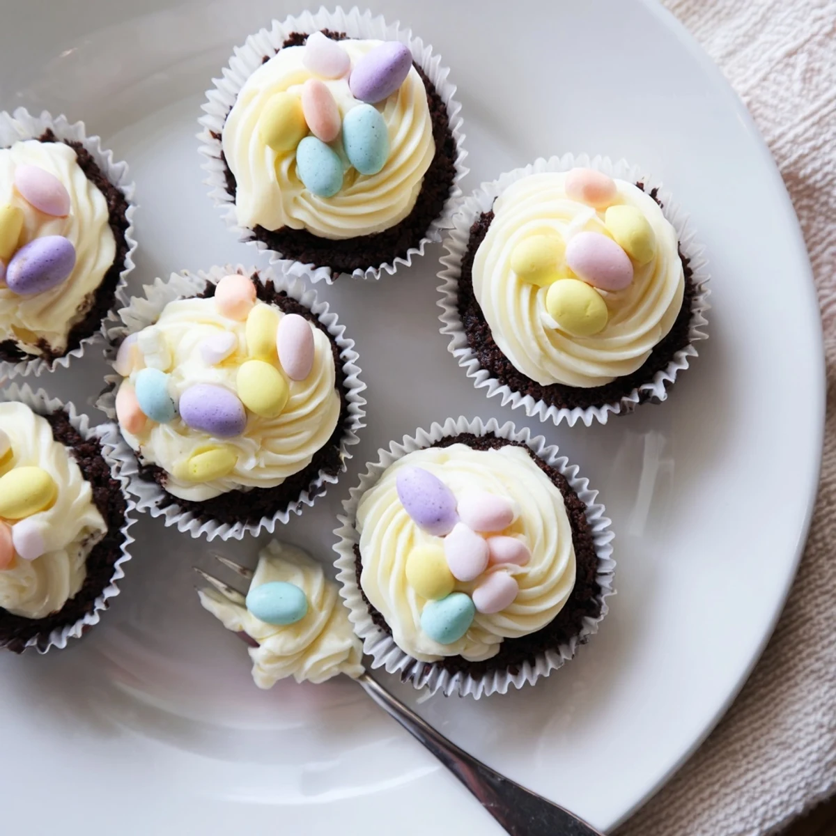 Delicious Easter Cadbury Mini Cheesecakes sitting in paper liners with chopped chocolate candy pieces on top