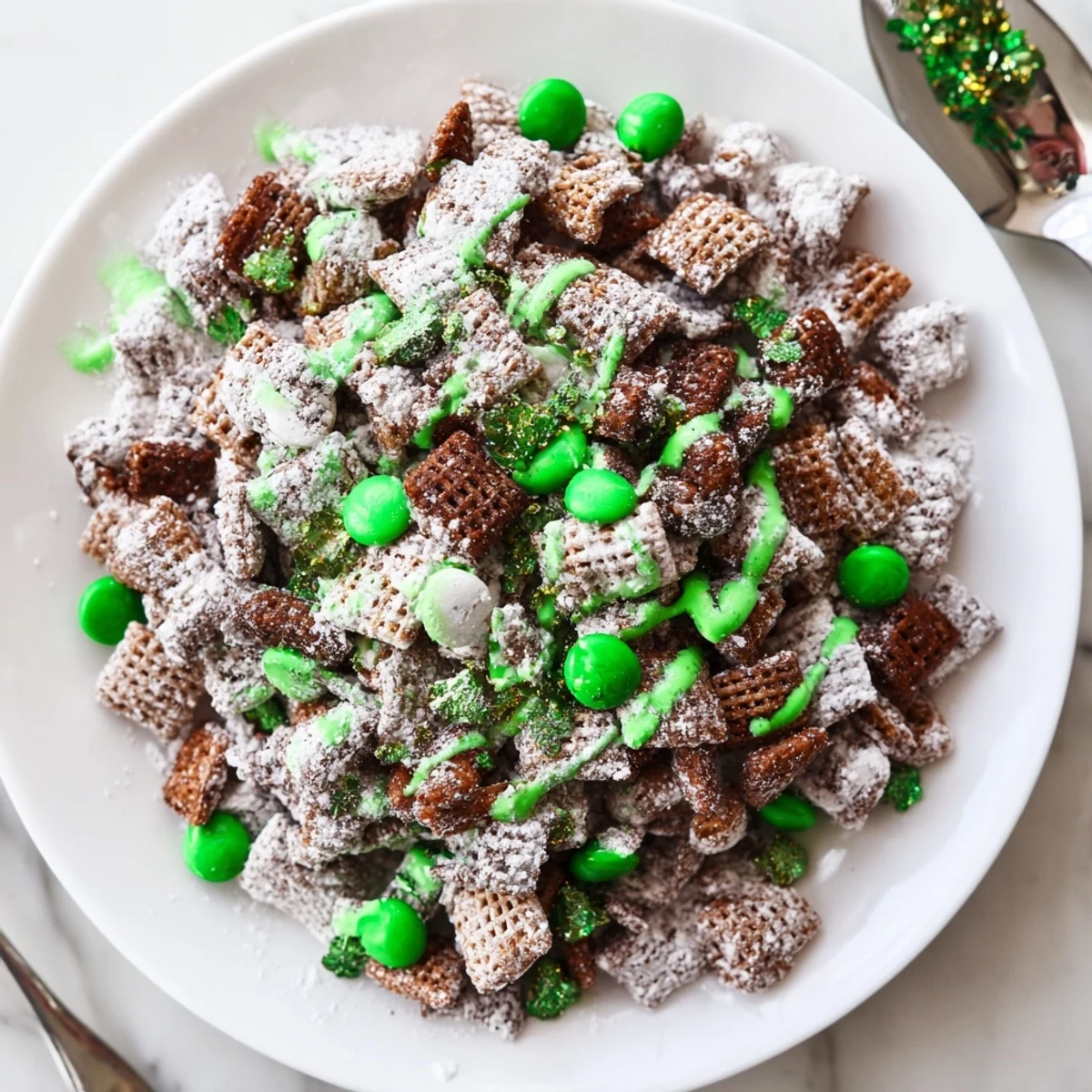 Bowl of St. Patricks Day puppy chow featuring chocolate peanut butter Chex cereal with vibrant green candies and sprinkles