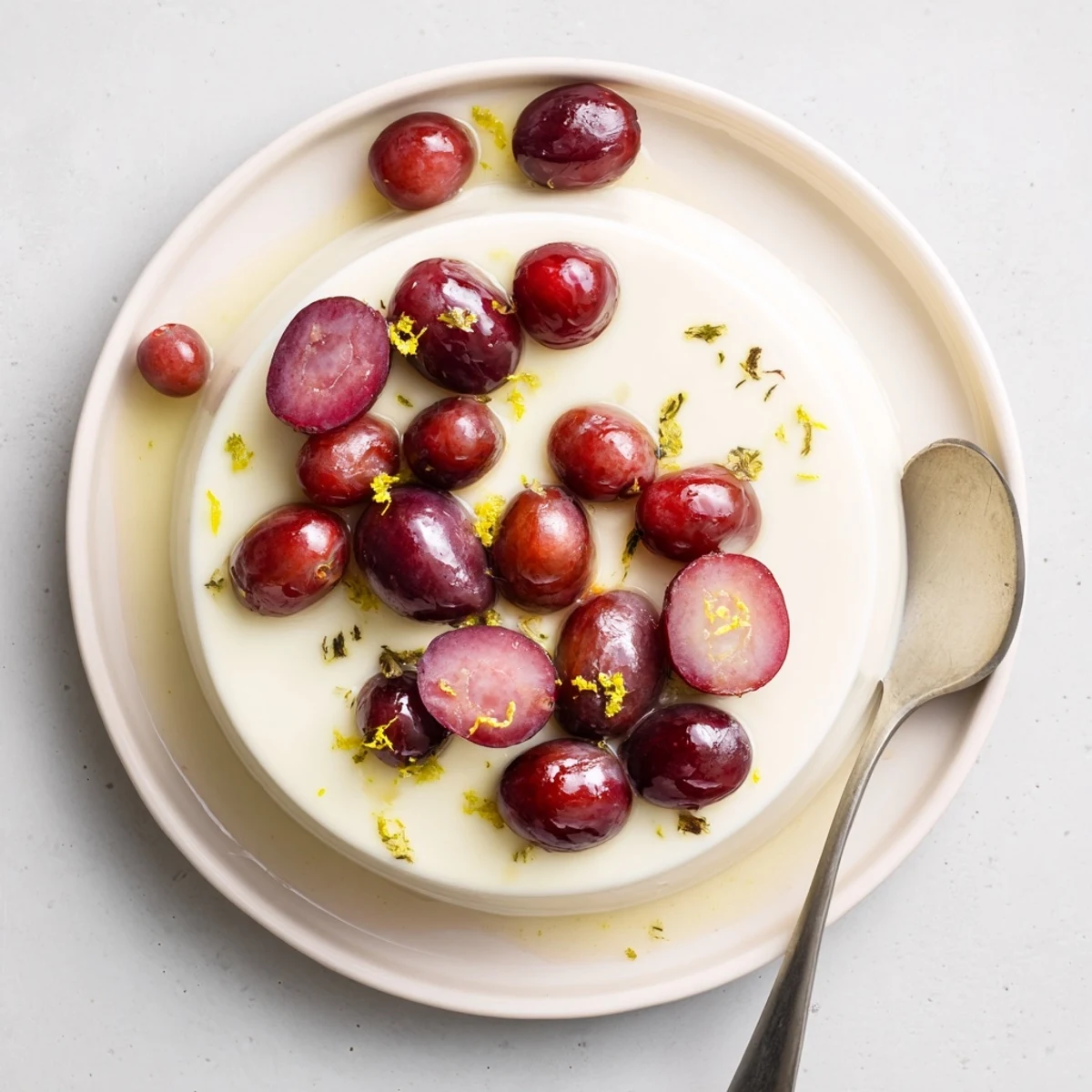 Silky citrus dessert garnished with honey roasted grapes and fresh grape halves