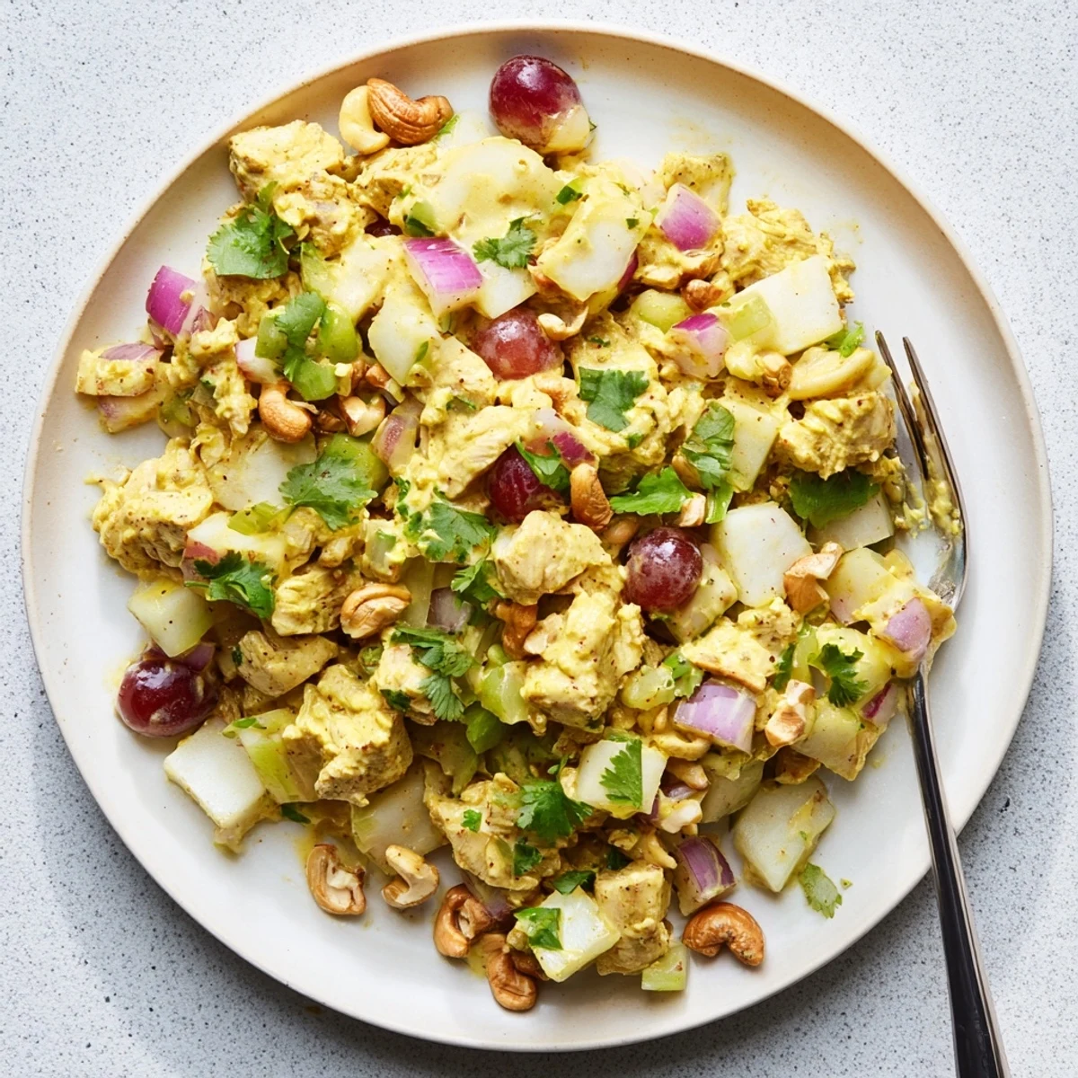 Creamy curry chicken salad loaded with diced chicken, red grapes, celery, and toasted cashews on a bed of fresh lettuce
