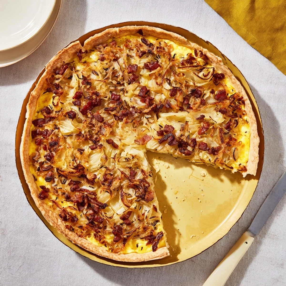 Golden German onion pie topped with caramelized onions and smoky bacon in a flaky pastry crust
