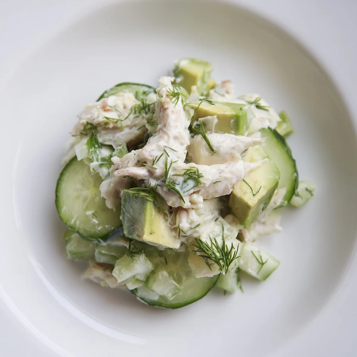 Crisp cucumber salad with crab meat topped with fresh dill and lemon wedges