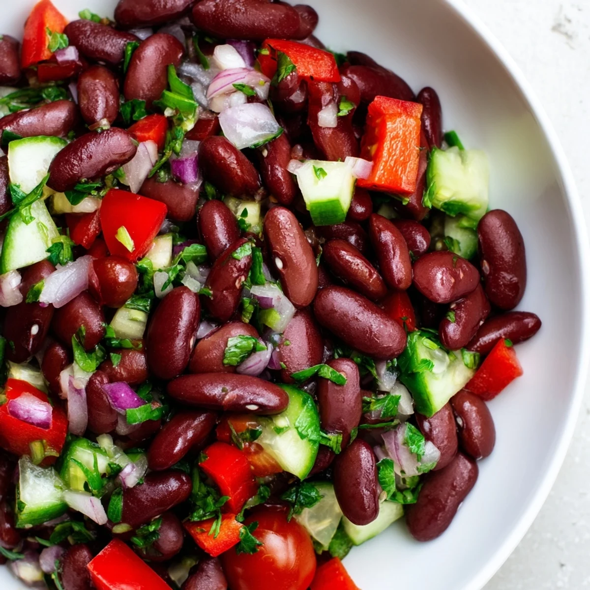 Kidney bean salad tossed with crisp vegetables and tangy vinaigrette in ceramic dish