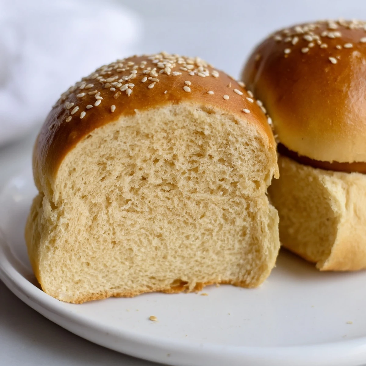 Soft homemade sourdough discard hot dog buns arranged on a wooden cutting board ready