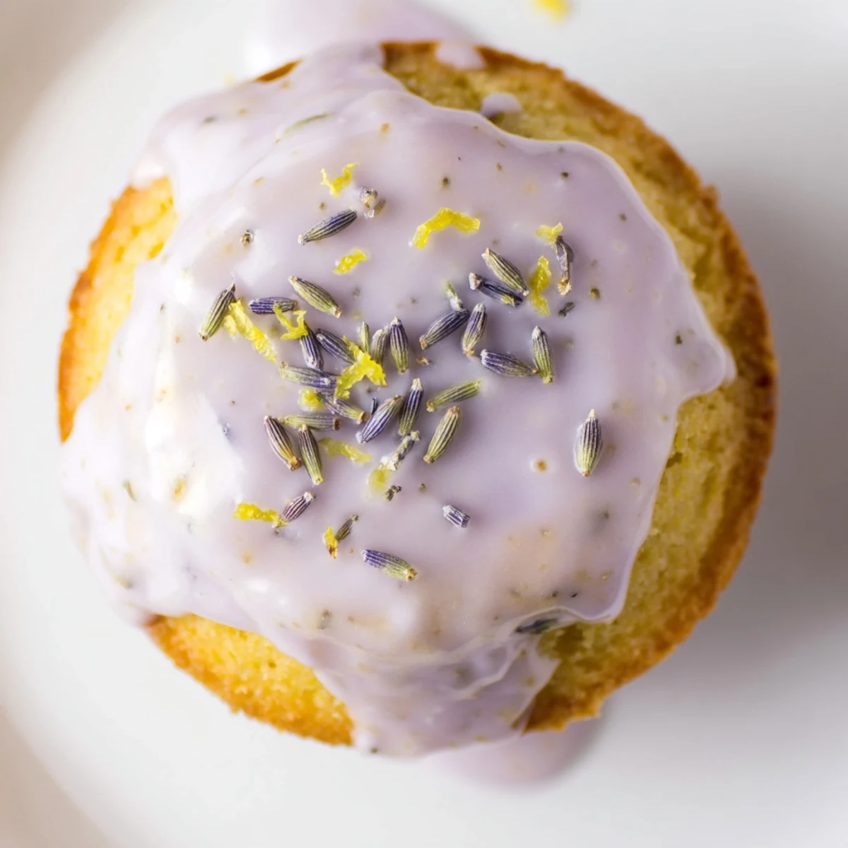 Soft mini lemon cakes with lavender glaze pooled on a wire cooling rack