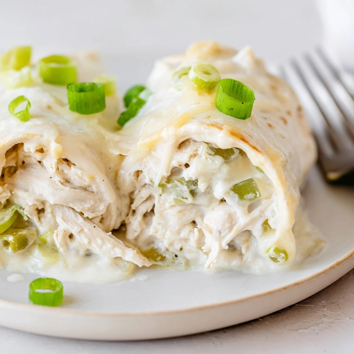 Warm Creamy White Chicken Enchiladas with melted Monterey Jack, steaming and comforting