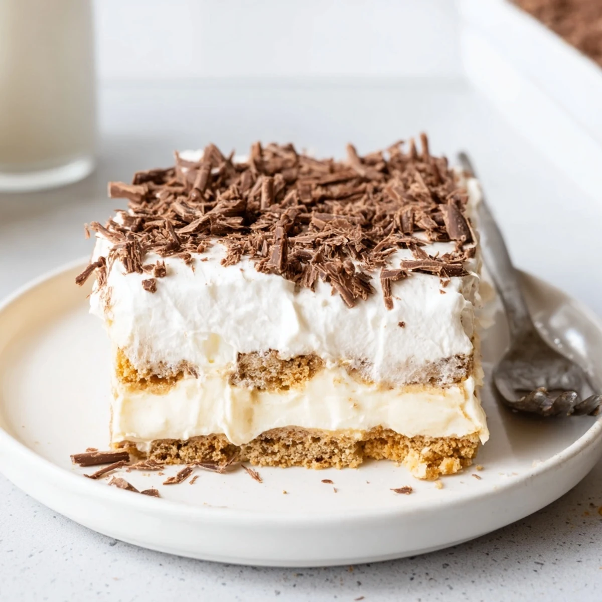 Sliced No Bake Layered Dessert showing cookie crust, whipped peaks, chocolate.