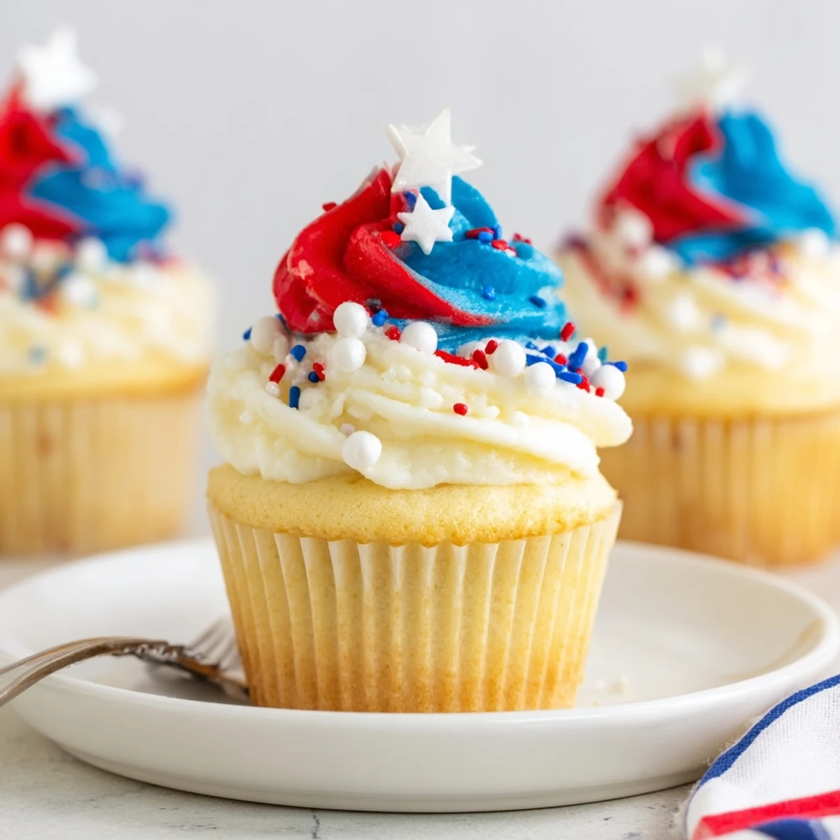 Patriotic Firework Cupcakes with tall red, white, and blue buttercream swirls