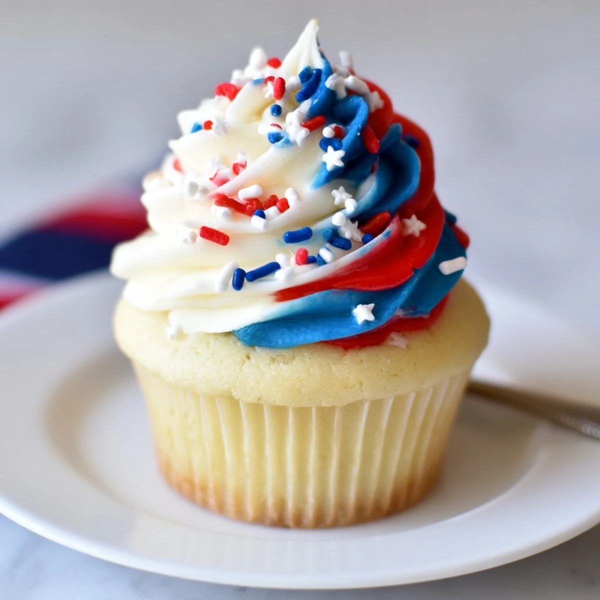 Freshly piped Patriotic Firework Cupcakes, fluffy vanilla cake paired with lemonade