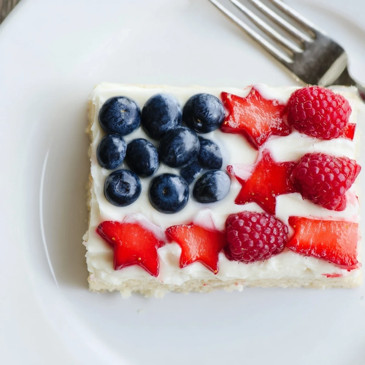 Slice of Sugar Cookie Flag Fruit Pizza served with sparkling lemonade nearby