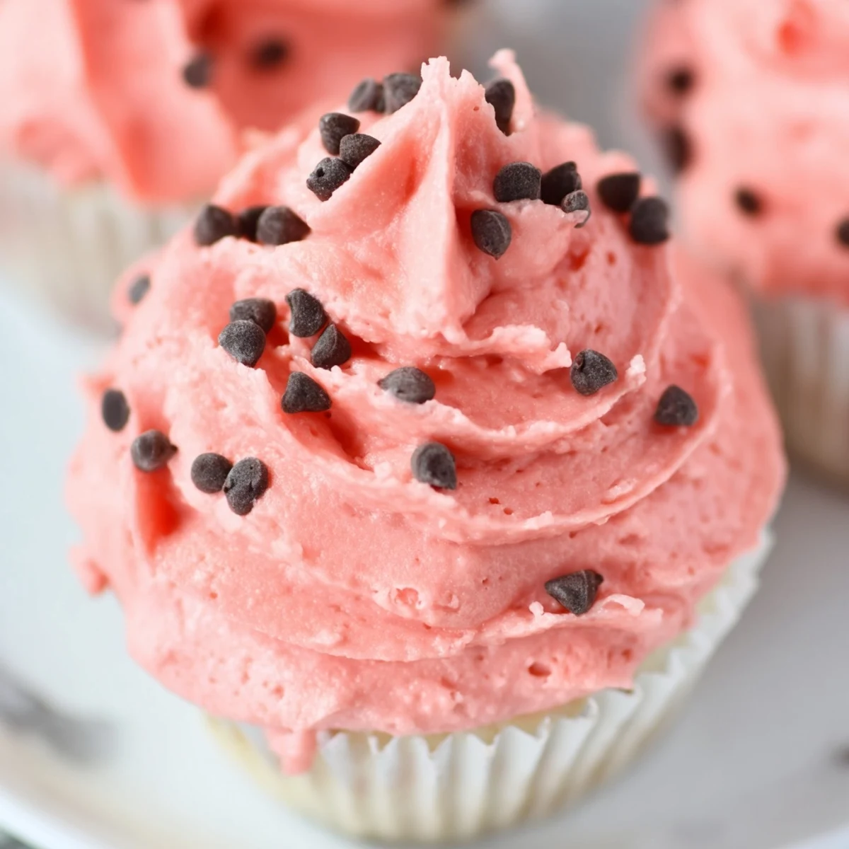 Fluffy watermelon cupcakes with swirled pink watermelon buttercream and green rind detailing for summer parties