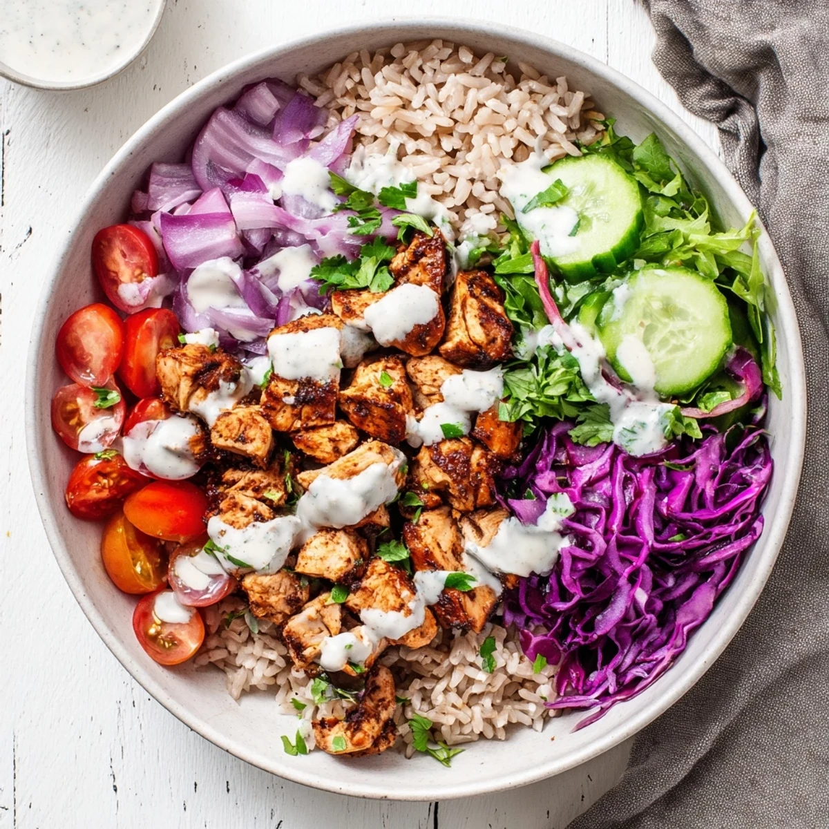Golden spiced chicken slices atop fluffy brown rice surrounded by colorful fresh vegetables in a healthy chicken shawarma bowl