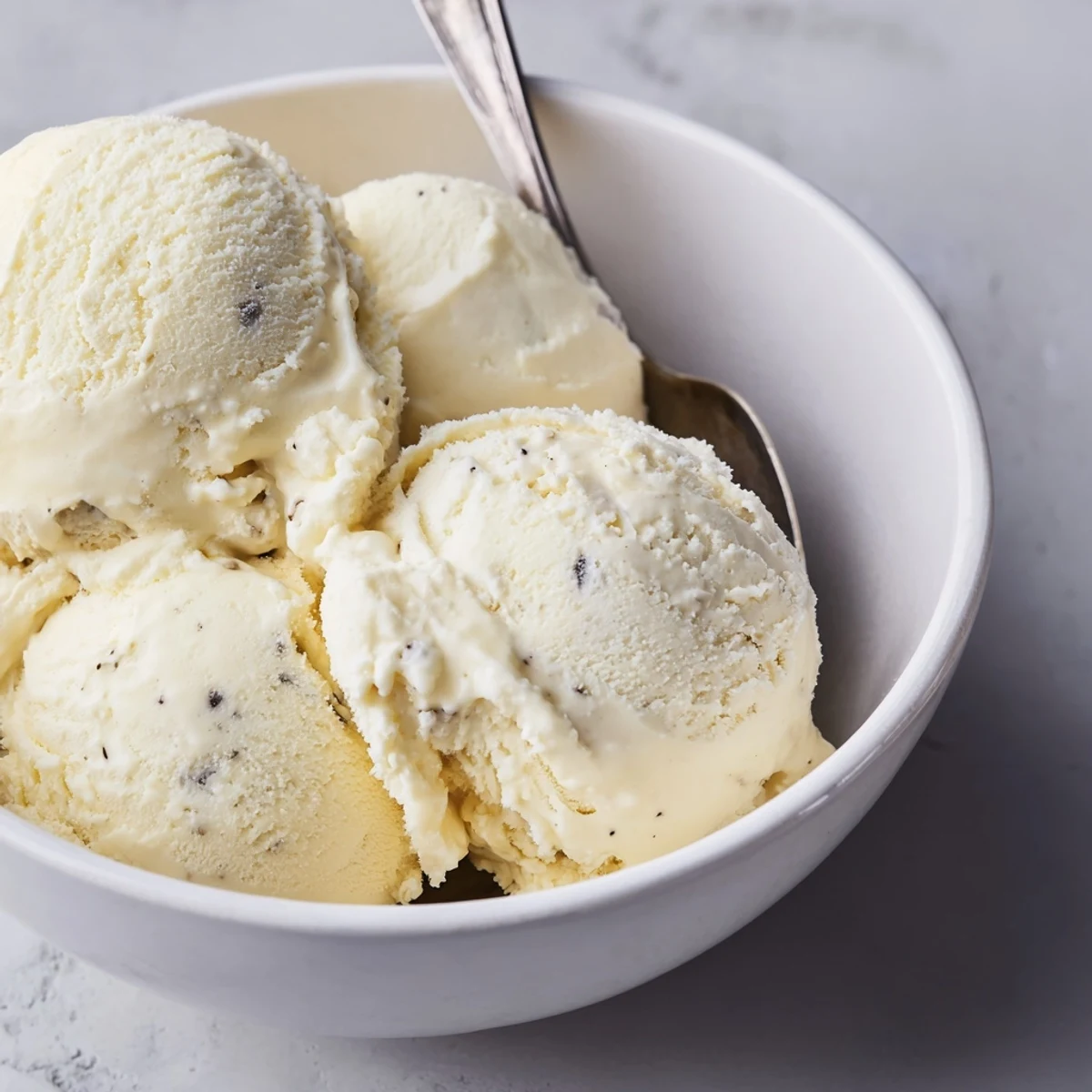 Creamy homemade vanilla ice cream served in a chilled glass bowl with fresh summer berries