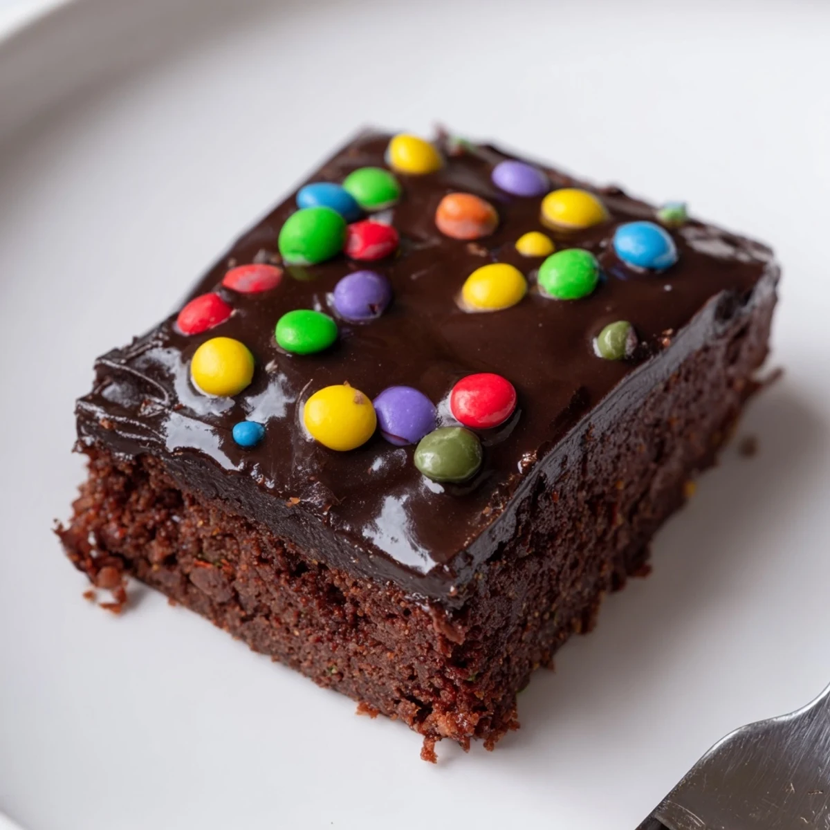 Slice of Gourmet Cosmic Brownies Bars on parchment, fudgy center visible