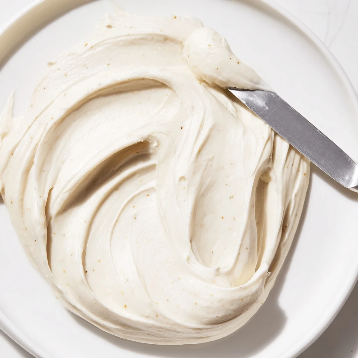Glossy Italian Meringue Buttercream smoothed onto a towering three-layer celebration cake