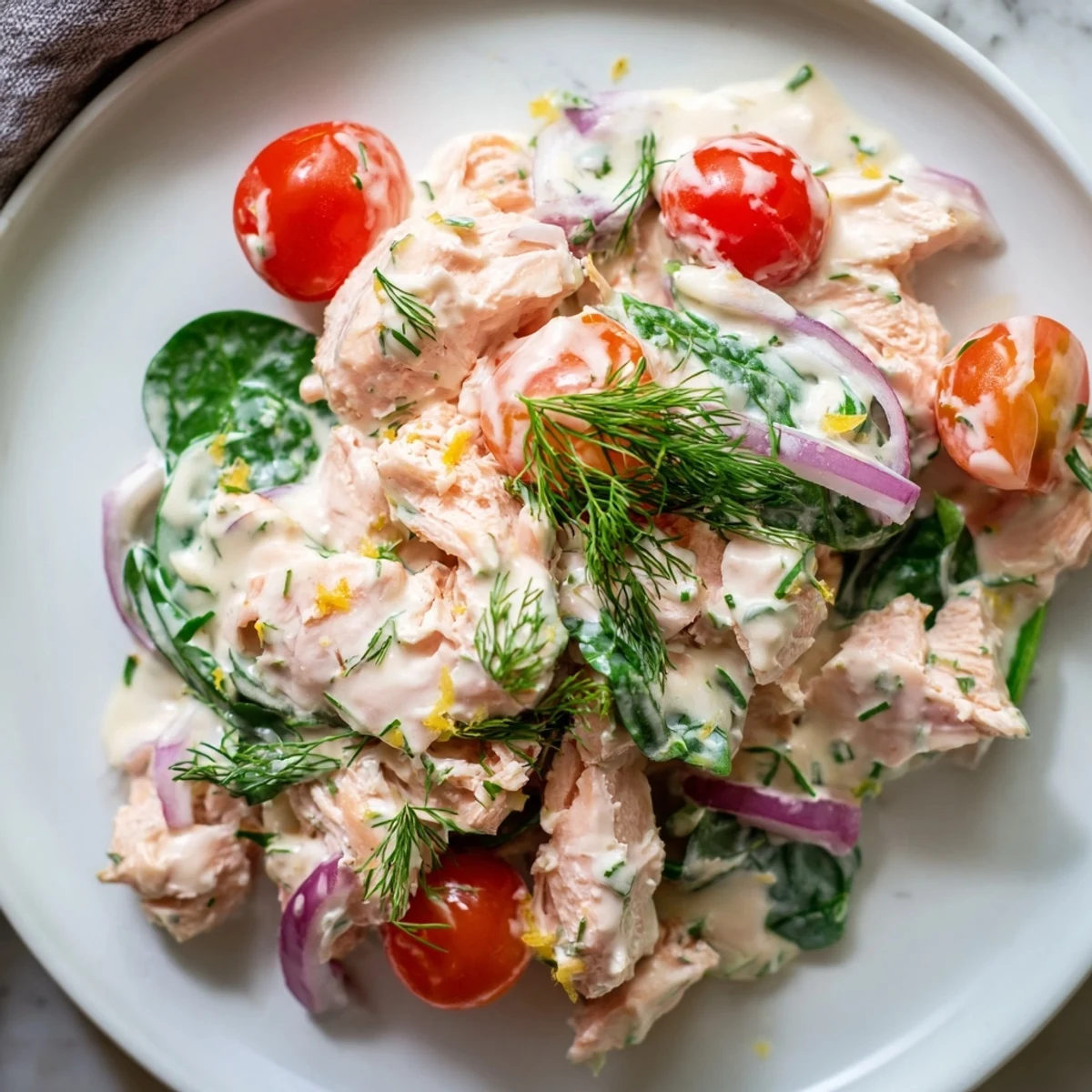 Golden flakes of salmon in a creamy sauce with wilted spinach and chives