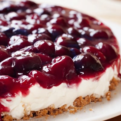 Homemade Classic Cherry Delight dessert served chilled with a dollop of whipped cream and a sprinkle of crust crumbs.