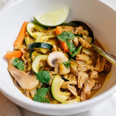 Steaming Jackfruit and Mushroom Balinese Curry served over fluffy white rice in a shallow bowl with scattered cilantro leaves.