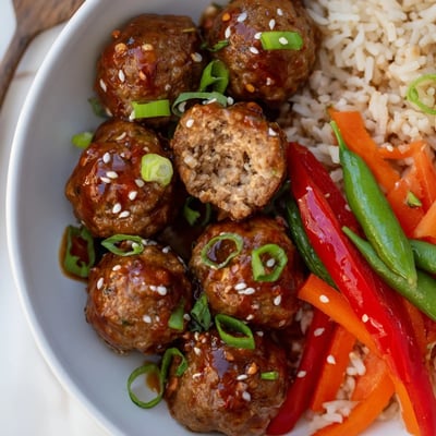 Baked Hello Fresh Firecracker Meatballs tossed in spicy sweet sauce with sesame